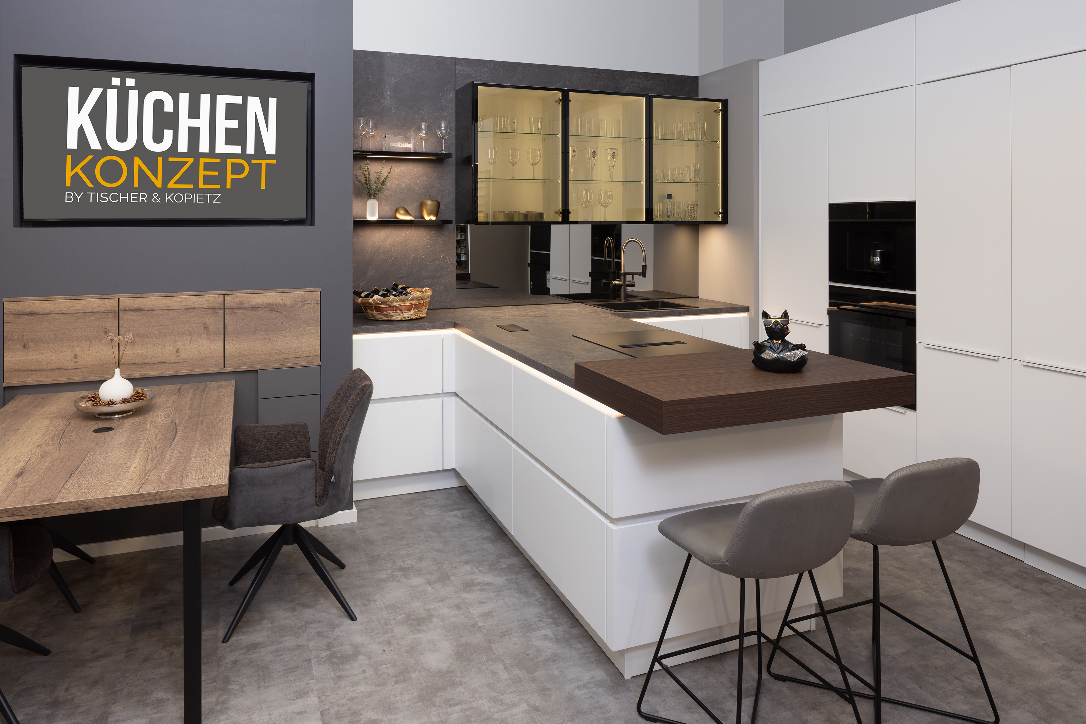 Moderne weiße Küche mit Kochinsel, Essbereich und zwei grauen Barhockern.