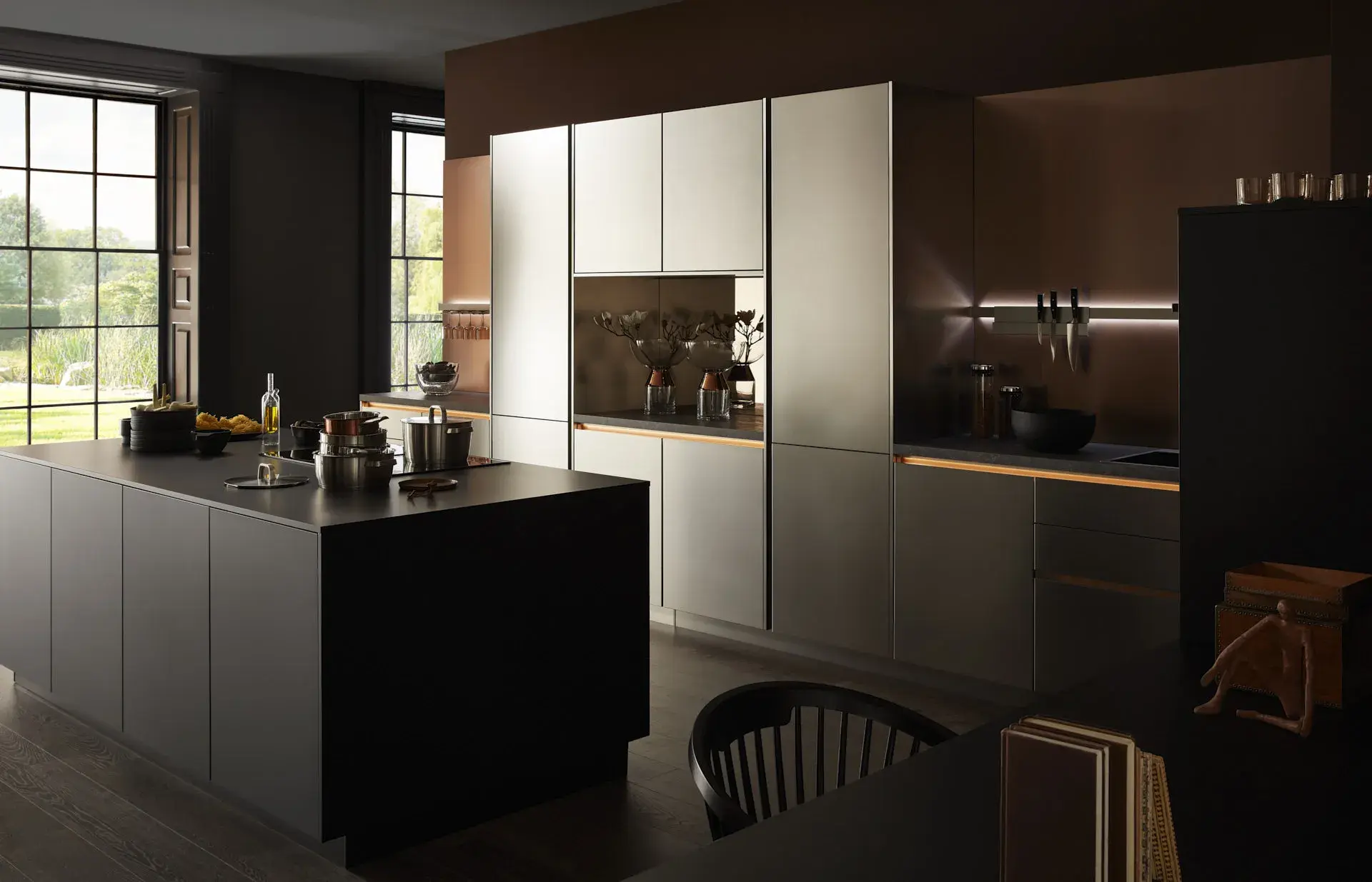 Gegenschuss, Mix aus Keramik und Bronzenachbildung, Kücheninsel mit Bosch Induktionskochfeld und Muldenlüfter, schwarzer Schrank, Edelstahlfronten, Bronze Nischenrückwand, 2 Bosch Einbaubacköfen, Messing Spüle